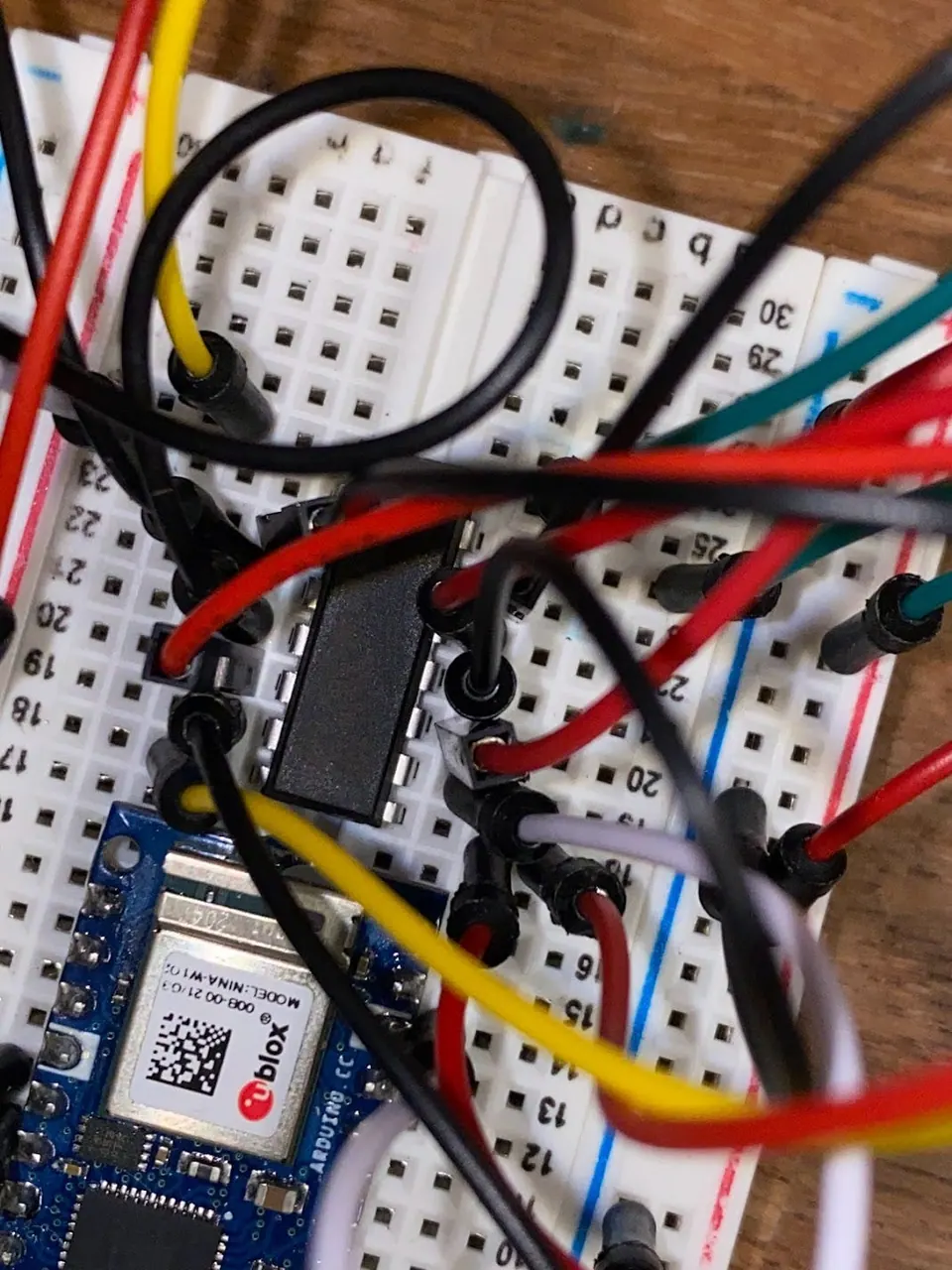 Overhead view of the breadboard with the L293D chip, the Arduino and a tangle of red, black, yellow and white wires