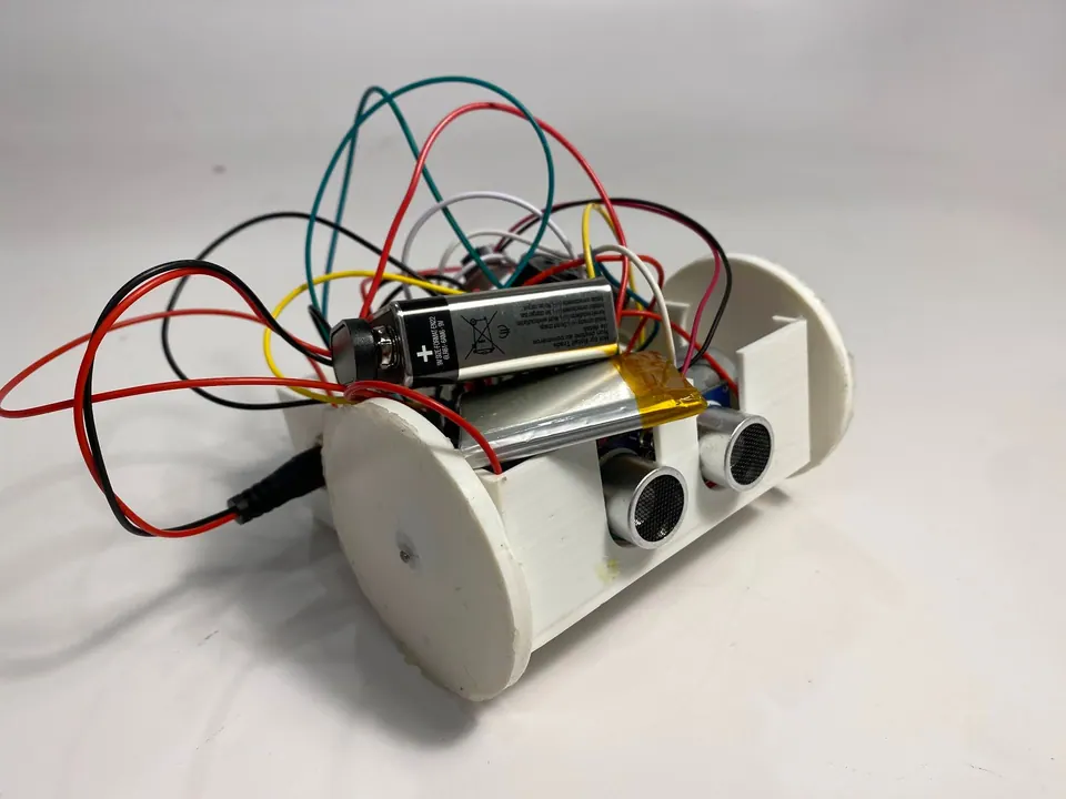 The finished RobotScreamer robot on a white background, with an ultrasonic sensor on the front and a 9V battery and loose wires on top