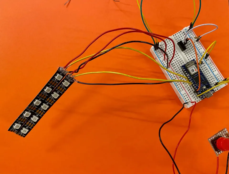 Two NeoPixel strips wired to an Arduino Nano 33 IoT on a breadboard with a red button, on an orange background