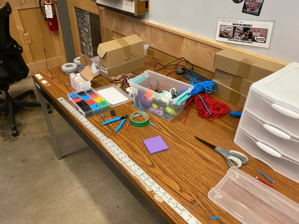 Lab workbench cluttered with a tray of supplies, a ruler, scissors, tape and paracord