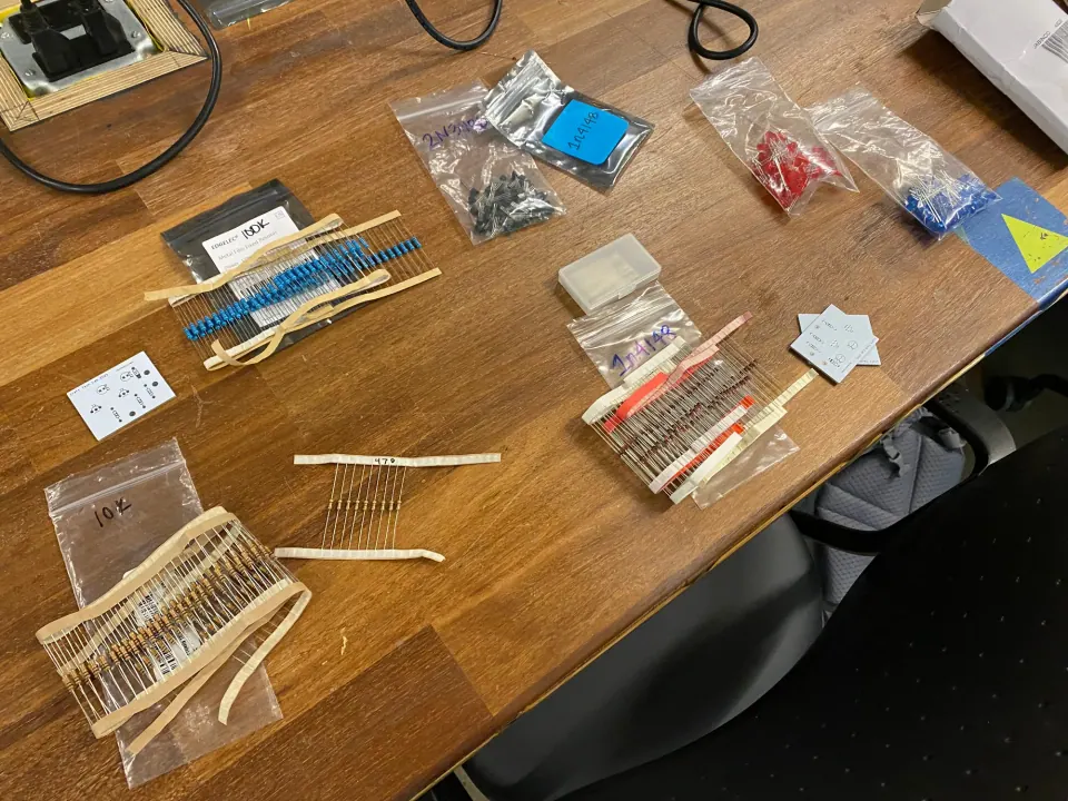 Bags of resistors, LEDs and other components laid out on a wooden table