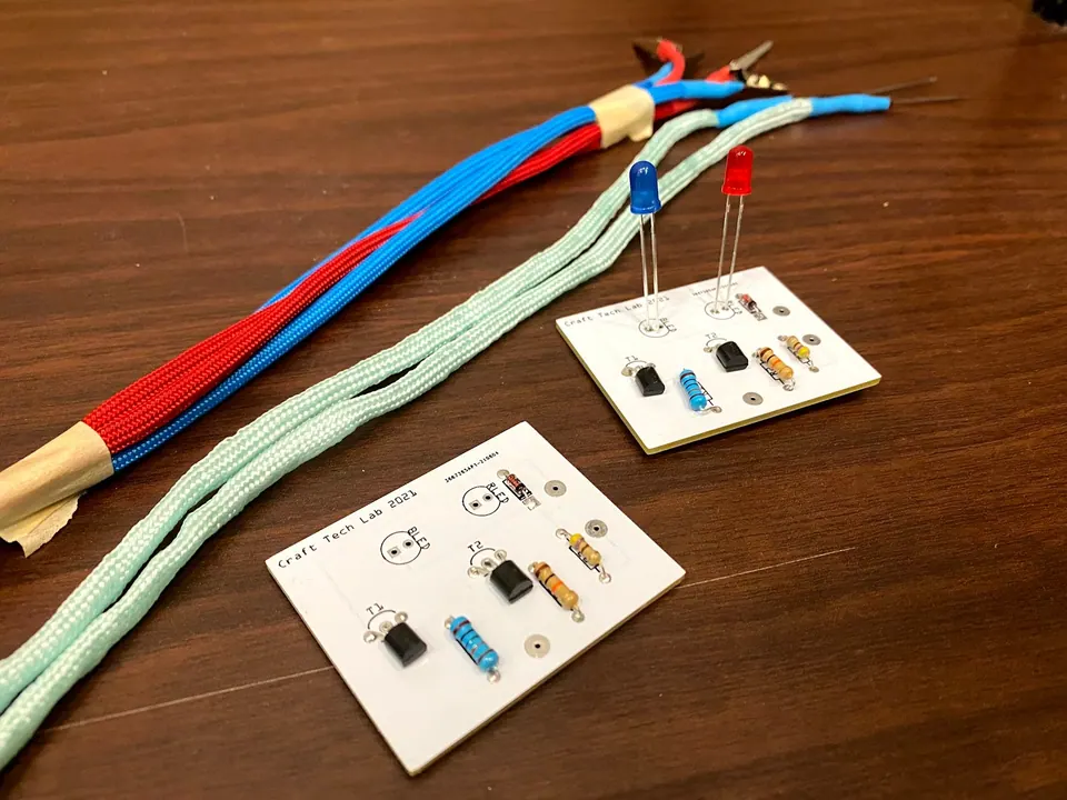 Bundle of blue and red cords and two mint probe cords lying beside two assembled circuit boards with LEDs standing up