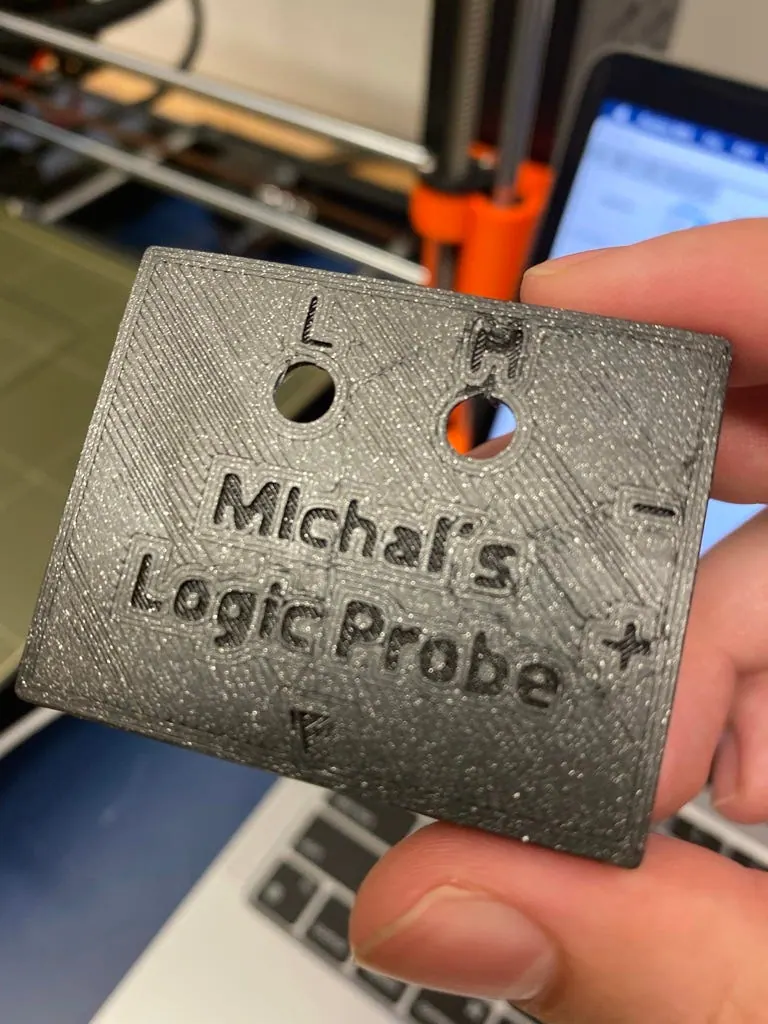 Hand holding the reprinted housing top, with a clearer engraved name and the L and H holes