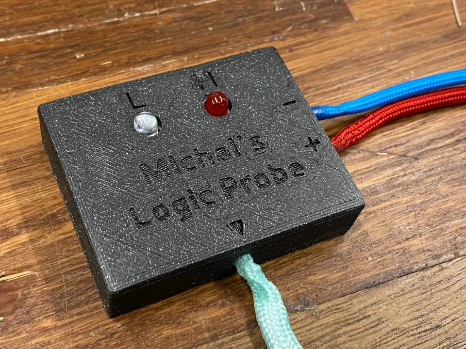 Finished black logic probe with white L and red H LEDs fitted, blue and red cords on the right and a mint cord at the bottom