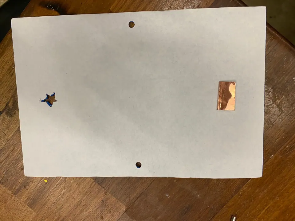 Back of the foam sheet showing a star-shaped cut-out, a copper pad and two punched holes