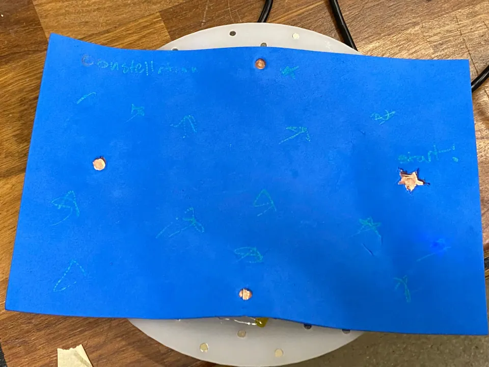 Blue foam with the constellation removed, showing three copper contact pads, the star cut-out and hand-drawn stars