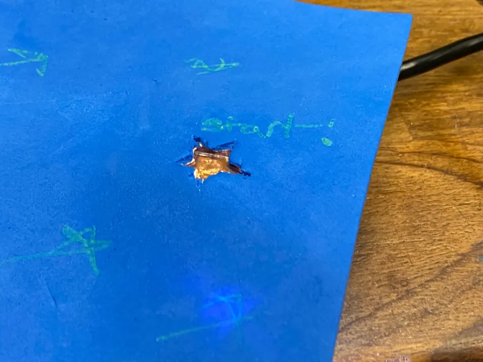 Close-up of the copper star contact pad in the blue foam, with handwritten start beside it and a faint blue glow